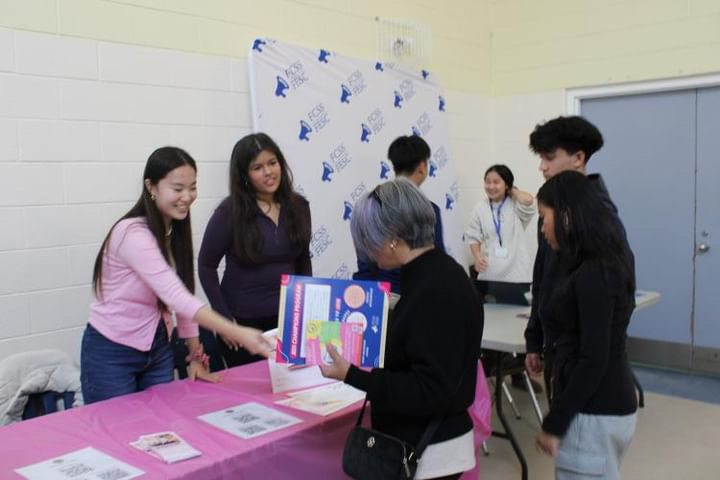 The Pink Stairs volunteers sharing books and speaking with visitors at a community event